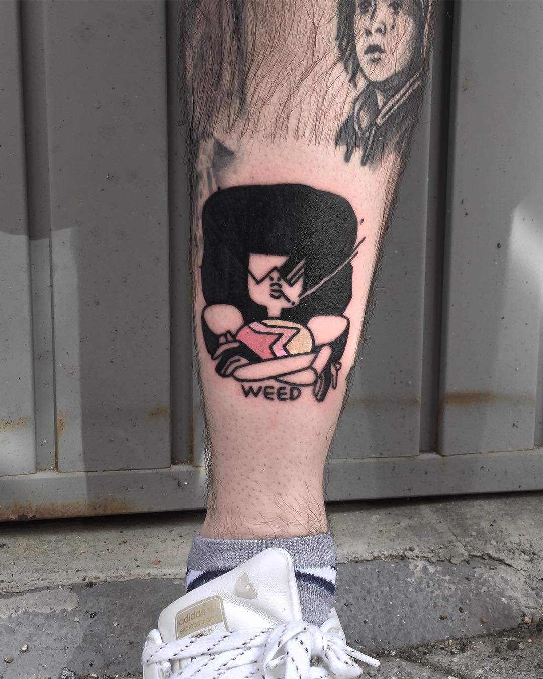 Black and red tattoo of Garnet from Steven Universe, featuring her in a determined pose with the word 'WEED' beneath, located on the lower leg