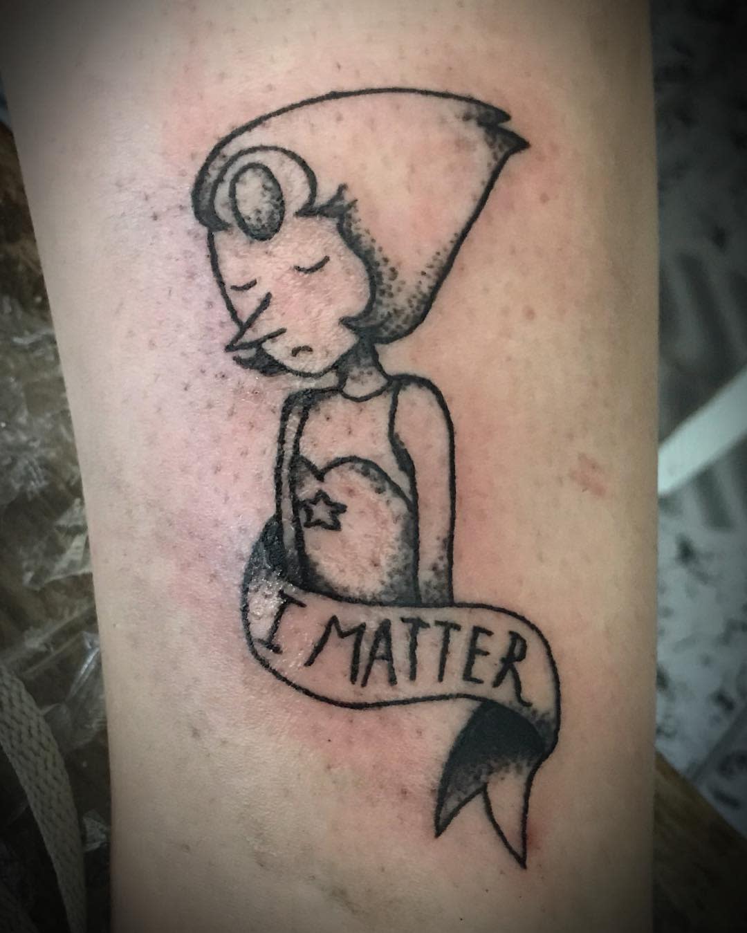 A simple yet powerful tattoo of Pearl from Steven Universe, featuring a banner that says 'I Matter,' emphasizing self-worth and resilience