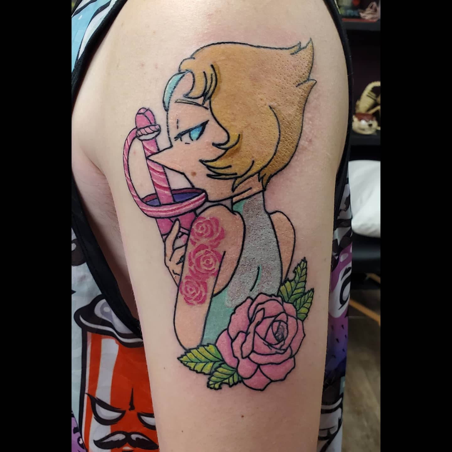 Stylized tattoo of Pearl from Steven Universe holding a pink sword, with roses on her arm and a large rose at her back, on the upper arm