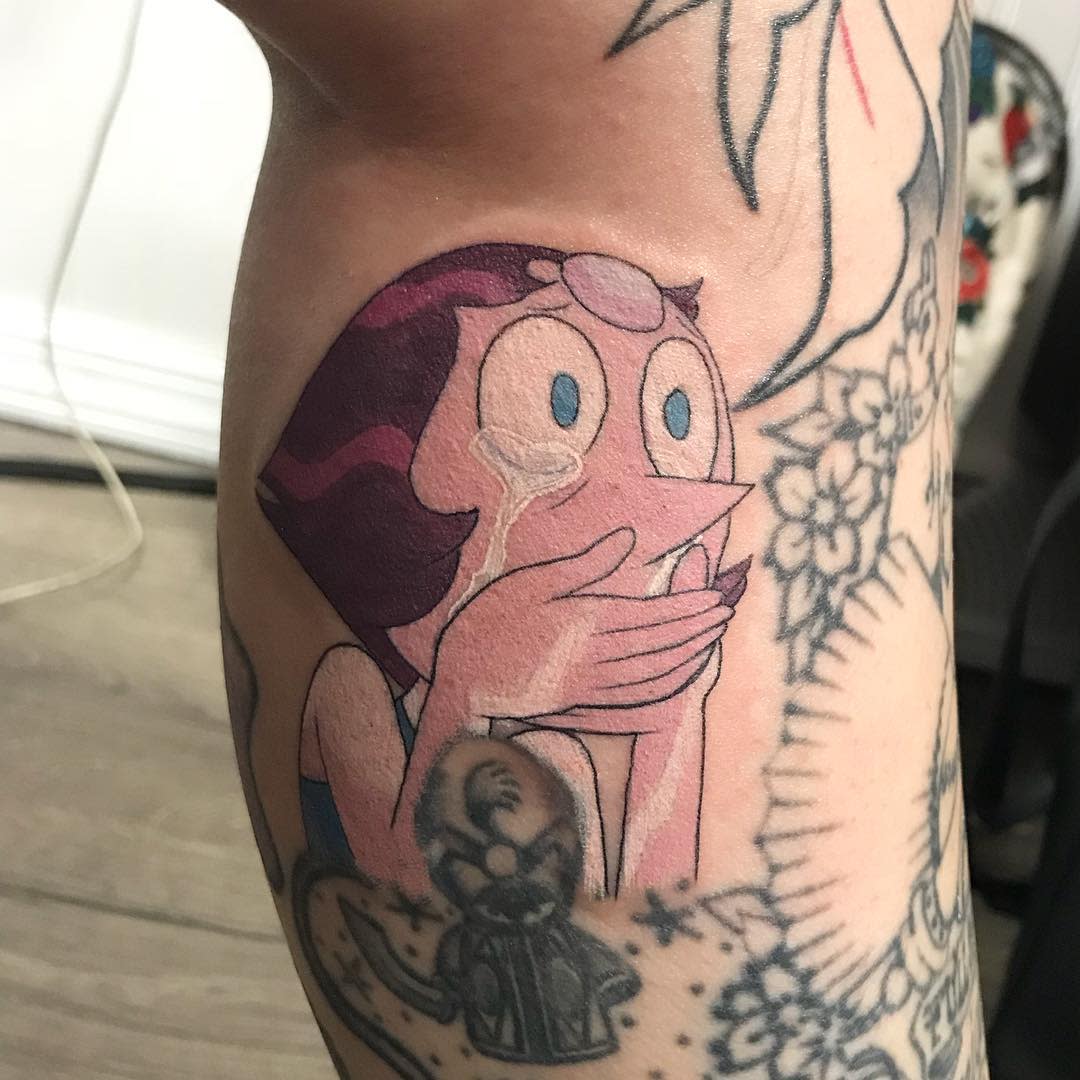 Emotional tattoo of Pearl from Steven Universe, depicted with tears in her eyes and hands covering her mouth, on the upper arm