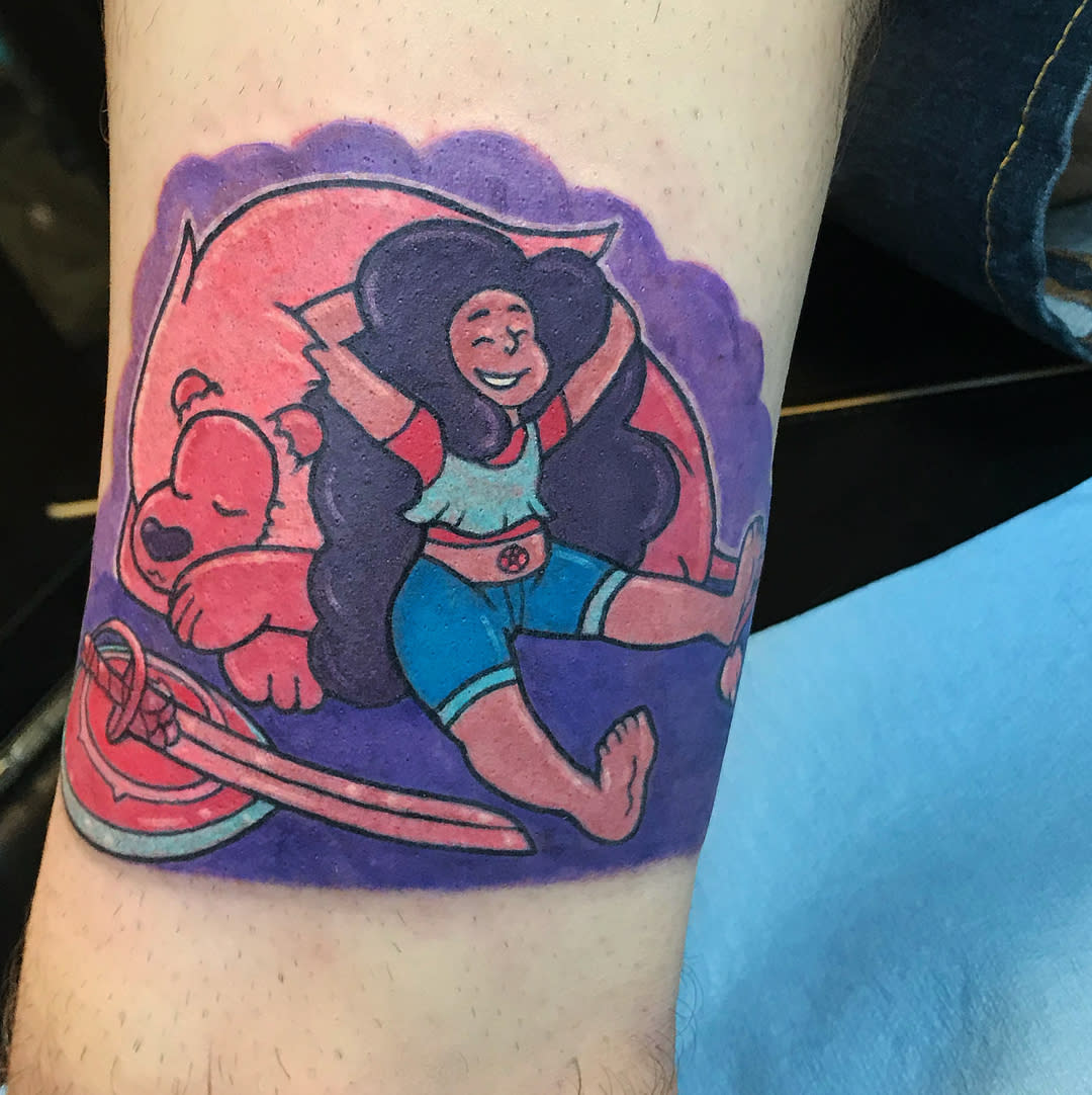 Colorful tattoo of Connie from Steven Universe relaxing with Lion, smiling joyfully, on the arm