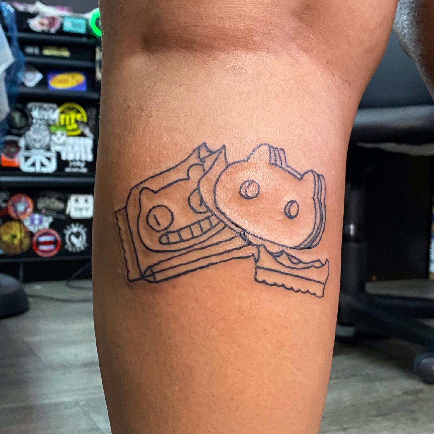 Outline tattoo of Cookie Cat from Steven Universe, with two stacked ice cream sandwiches on the leg