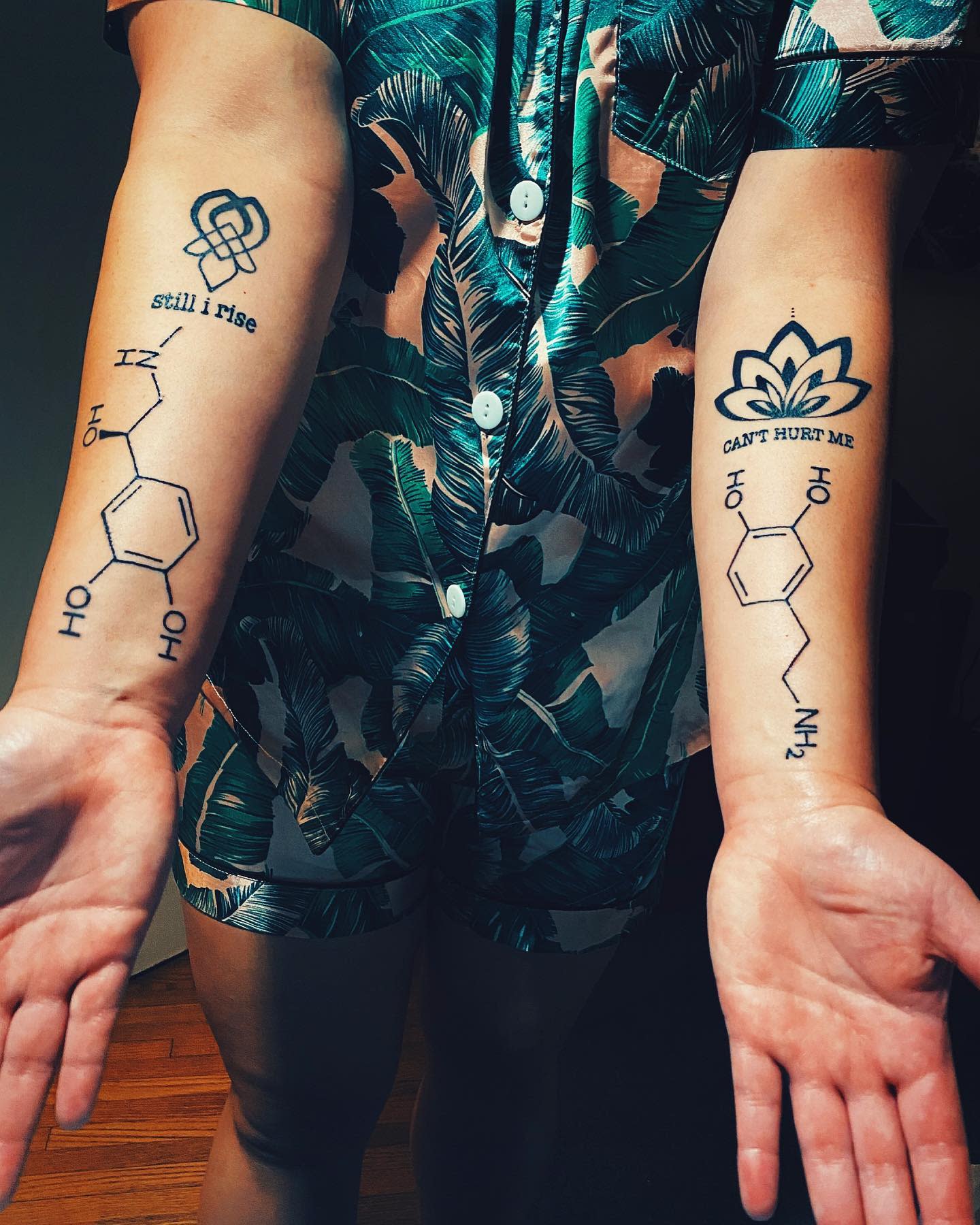 Individual with chemical structure tattoos and text on forearms