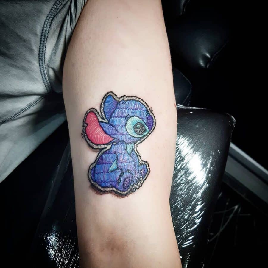Stitch-inspired tattoo featuring a cute Stitch design, crafted with detailed fabric-like embroidery for a plush effect.