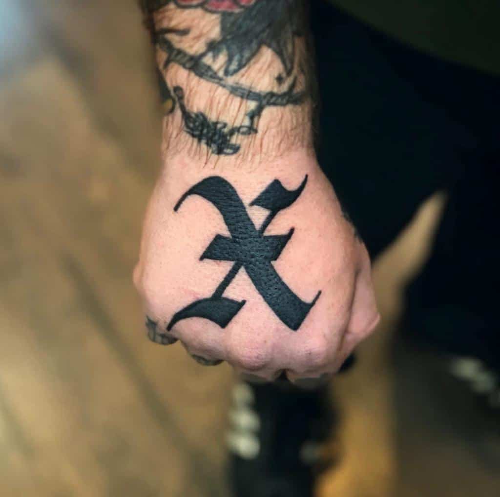 A straight edge tattooed hand with a bold, black letter "X" inked on the back