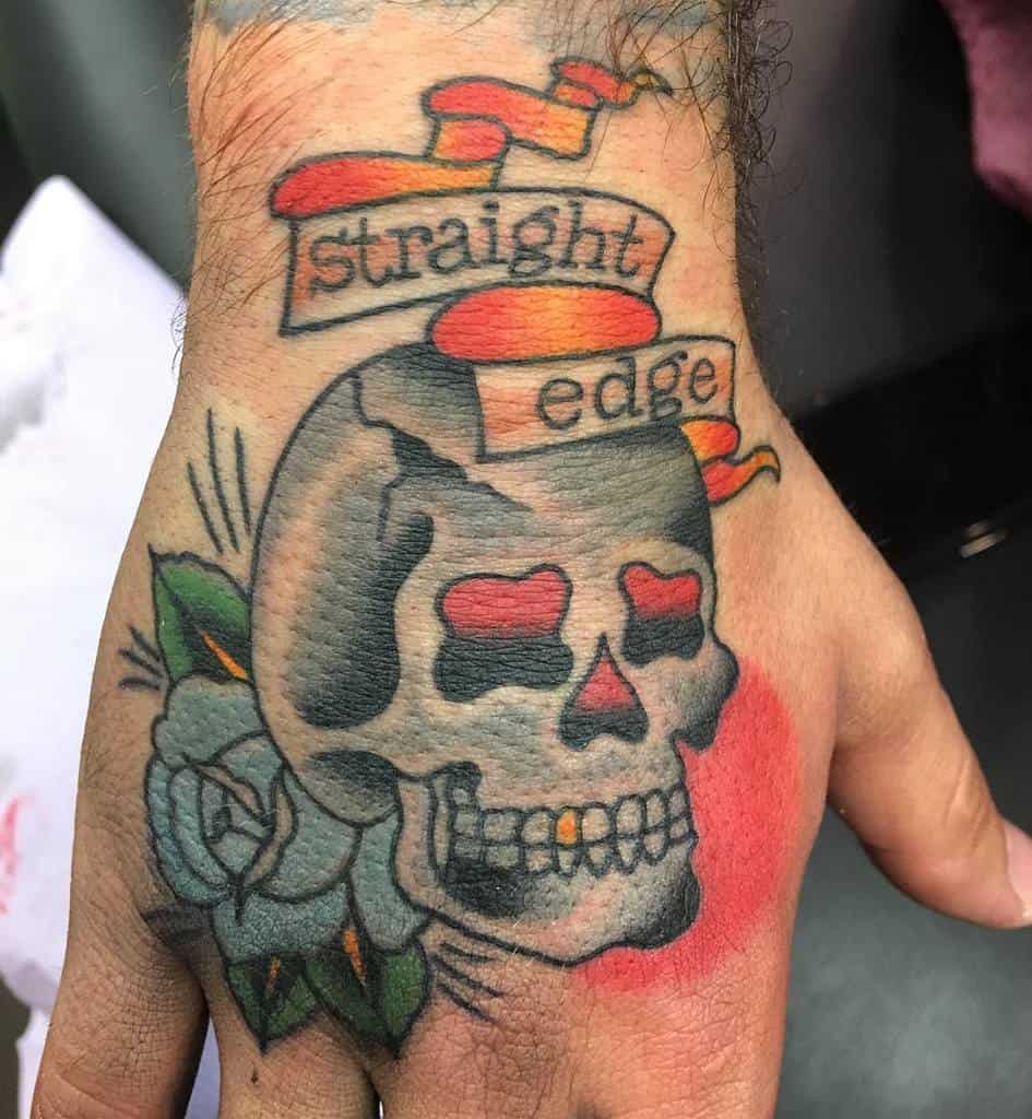 Bold hand tattoo featuring a skull with red eyes, a banner reading 'Straight Edge,' and a blue rose
