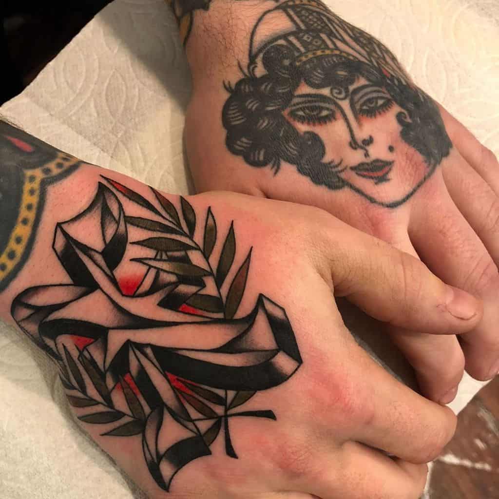 Bold black and red Straight Edge 'X' hand tattoo with intricate ribbon and leaf details, paired with a traditional-style woman's face on the other hand