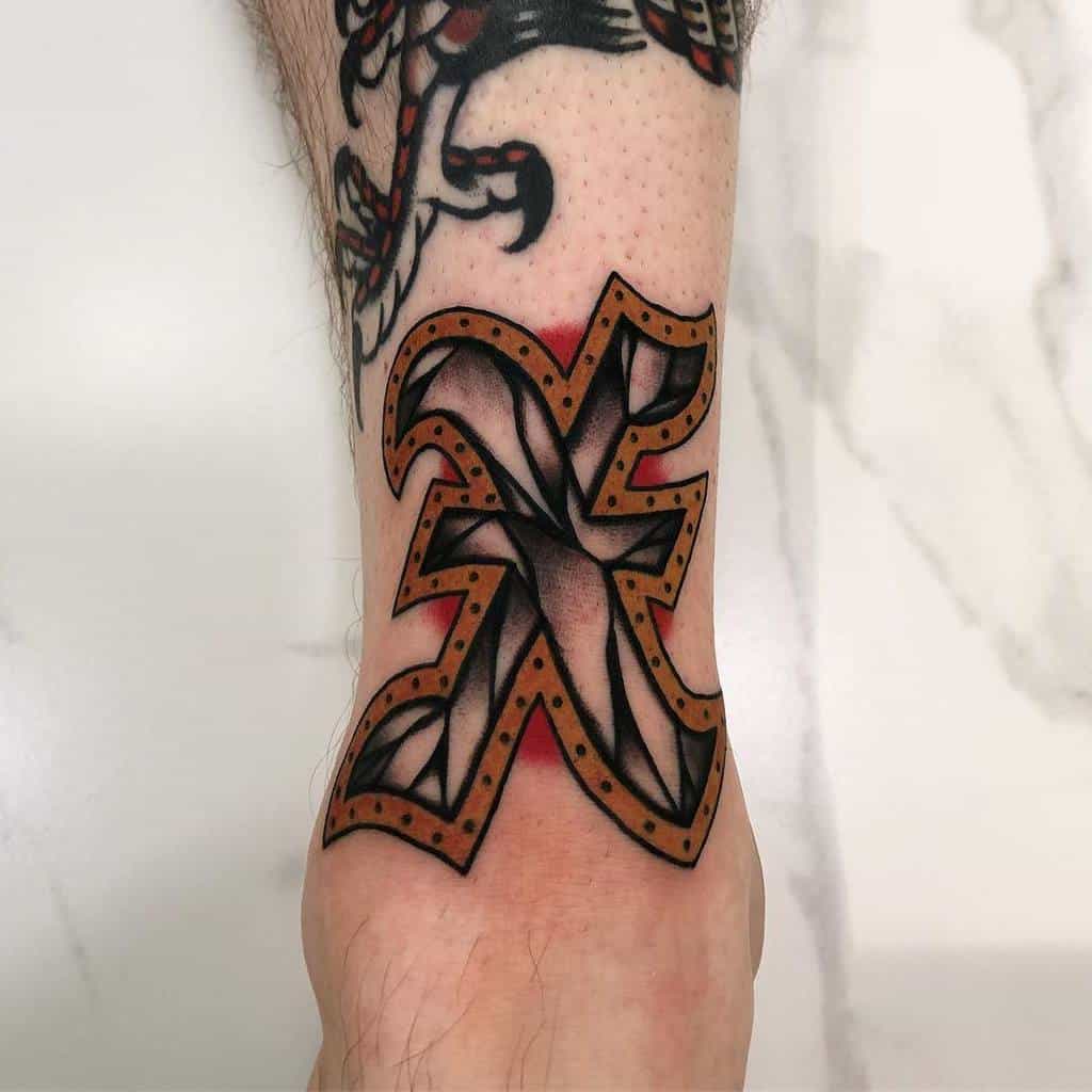 Bold straight edge tattoo featuring a stylized 'X' with jagged edges, shading, and a gold-outlined frame, creating a dynamic design