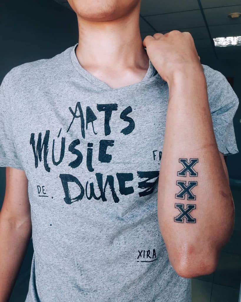 Straight edge tattoo with three bold 'X' symbols stacked vertically on the forearm, outlined in black for a clean and striking look