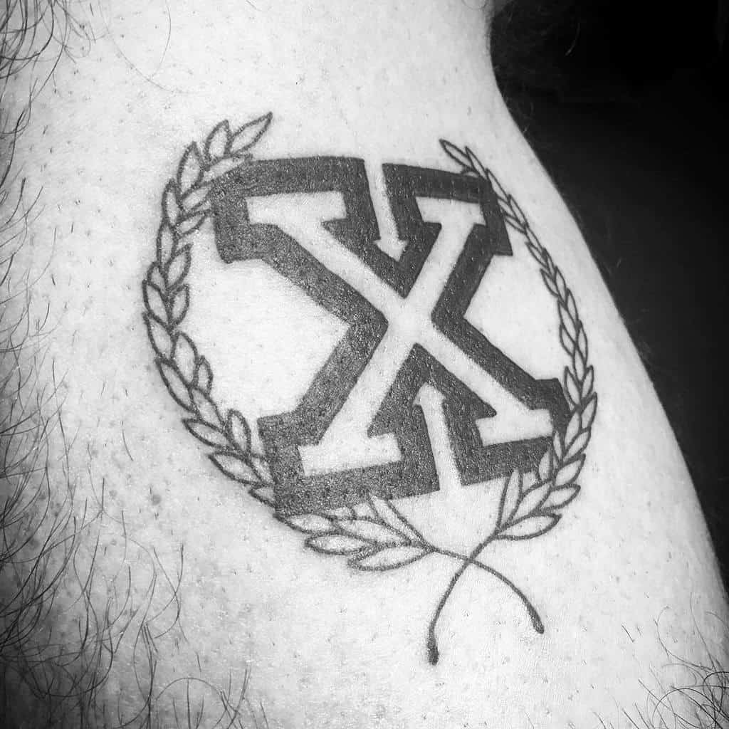 Straight edge tattoo of a stylized letter "X" surrounded by laurel branches