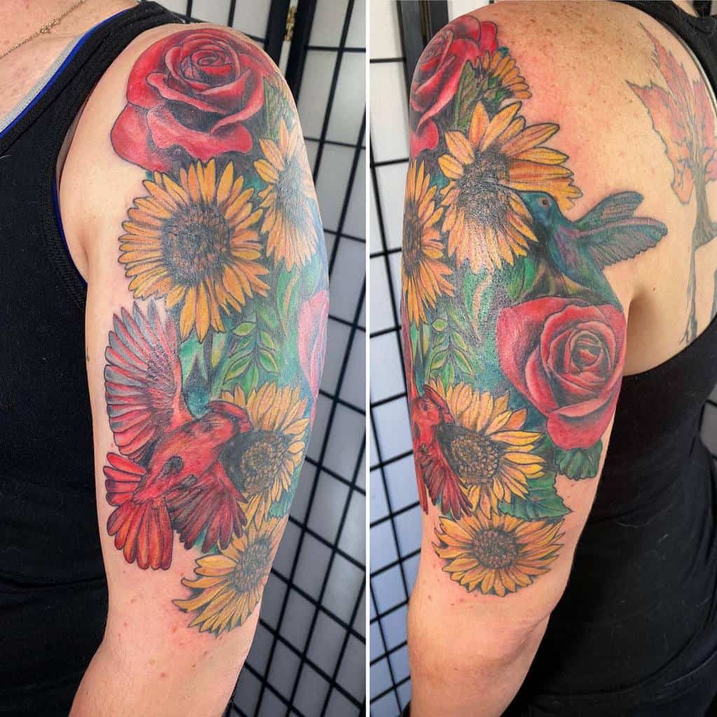 Vibrant arm tattoo of sunflowers, hummingbirds, and cardinals on the upper arm