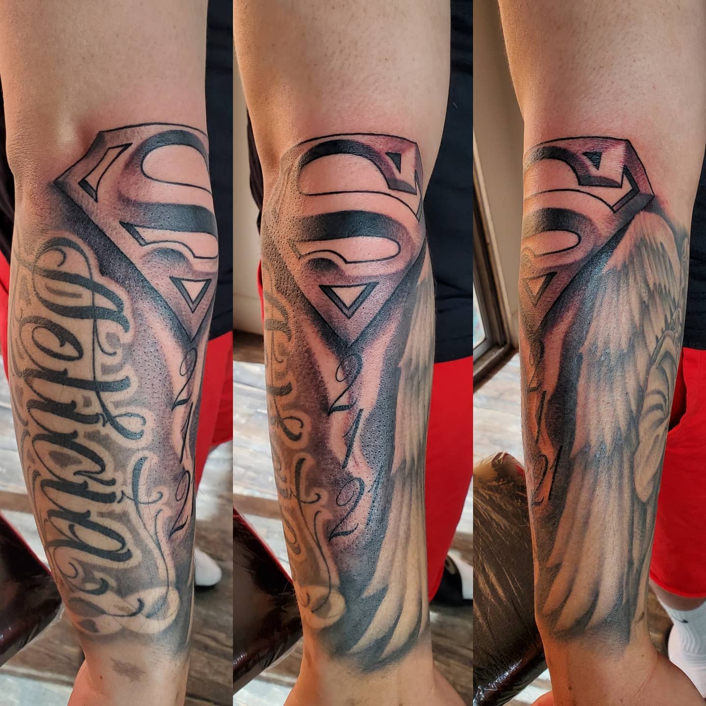 A forearm tattoo featuring the Superman logo, wings, and cursive text