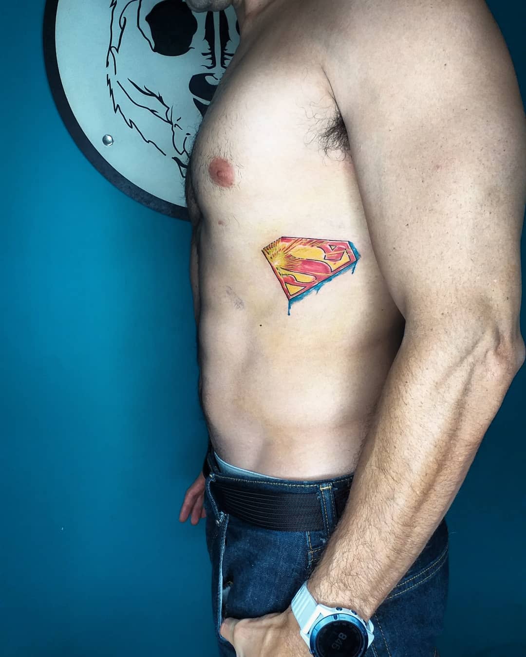 Man with Superman tattoo on right side of ribcage