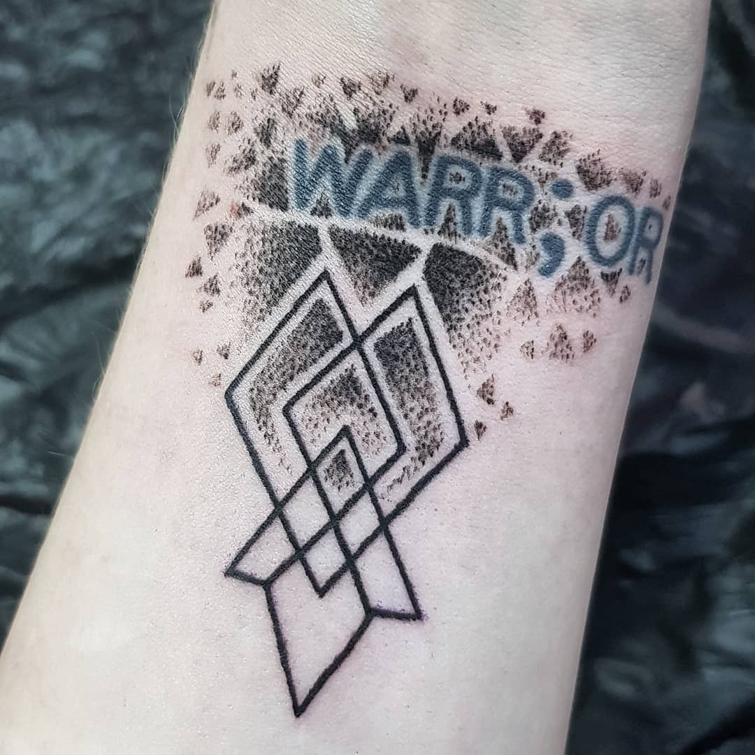 Tattoo on a forearm with geometric shapes and "WARR;OR" text above in bold letters