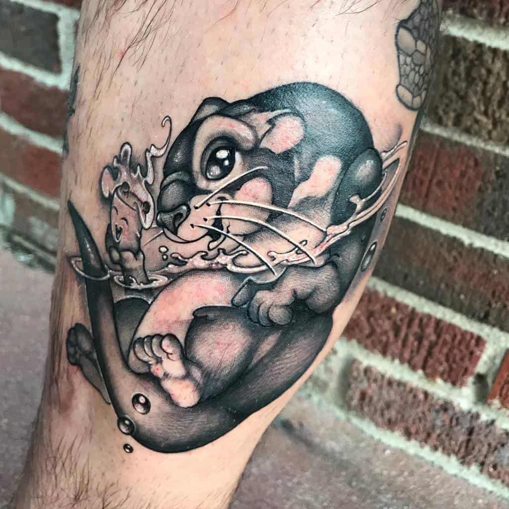 Detailed tattoo of a playful otter swimming with splashing water, featuring bold shading and expressive eyes for a lively design