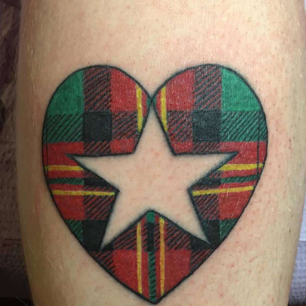 Bold tattoo of a heart-shaped Scottish tartan pattern with a central white star
