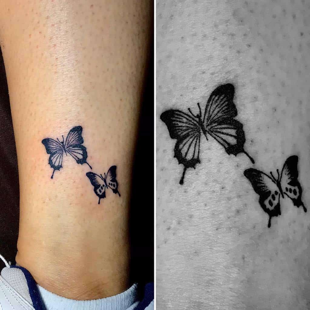 Tattoo of two small black butterflies above the ankle