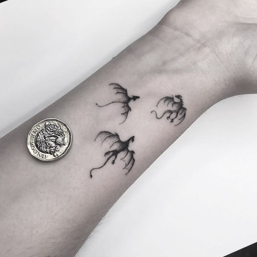 Wrist tattoo of three small dragons