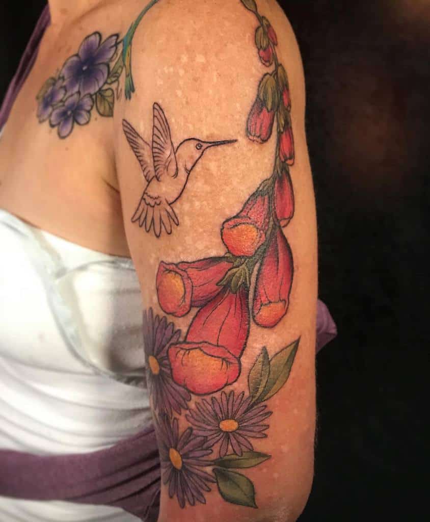 Arm tattoo with a hummingbird and colorful flowers, featuring purple and orange blossoms, and delicate asters