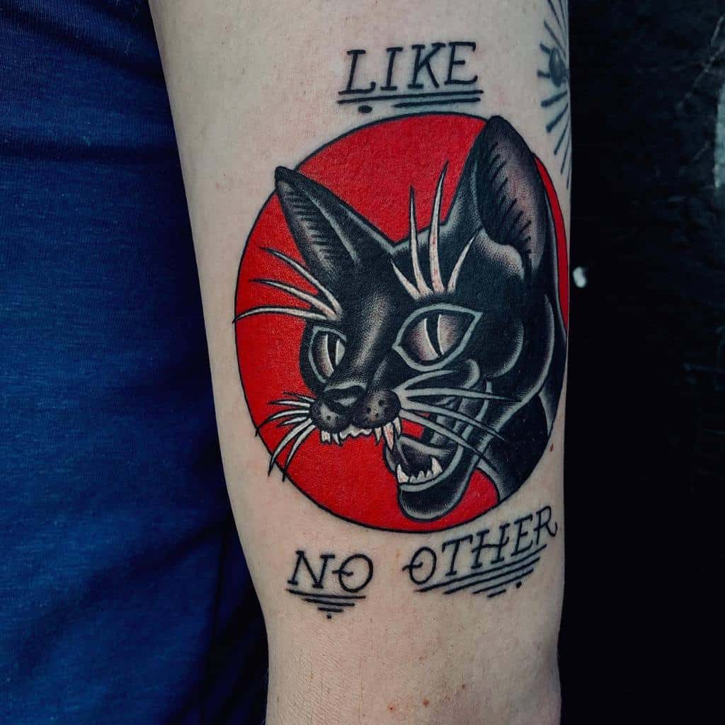 Tattoo of a snarling black cat with a red circle background and text "Like No Other"