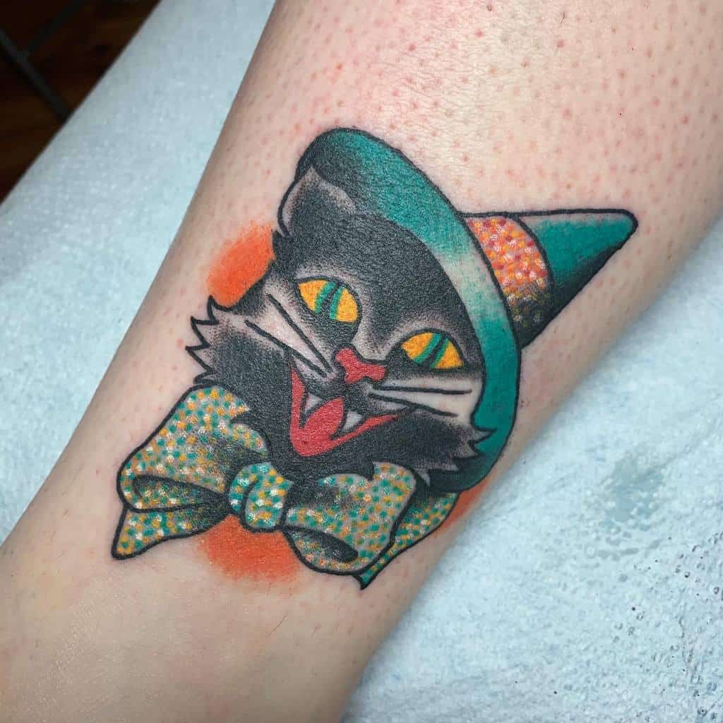 Tattoo of a sleek black cat in a green hat against an orange background