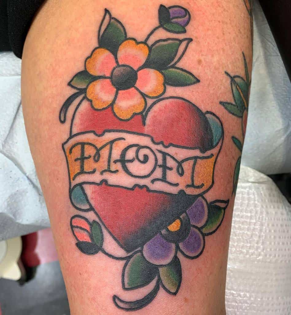 Tattoo of a heart adorned with flowers and a banner reading "MOM