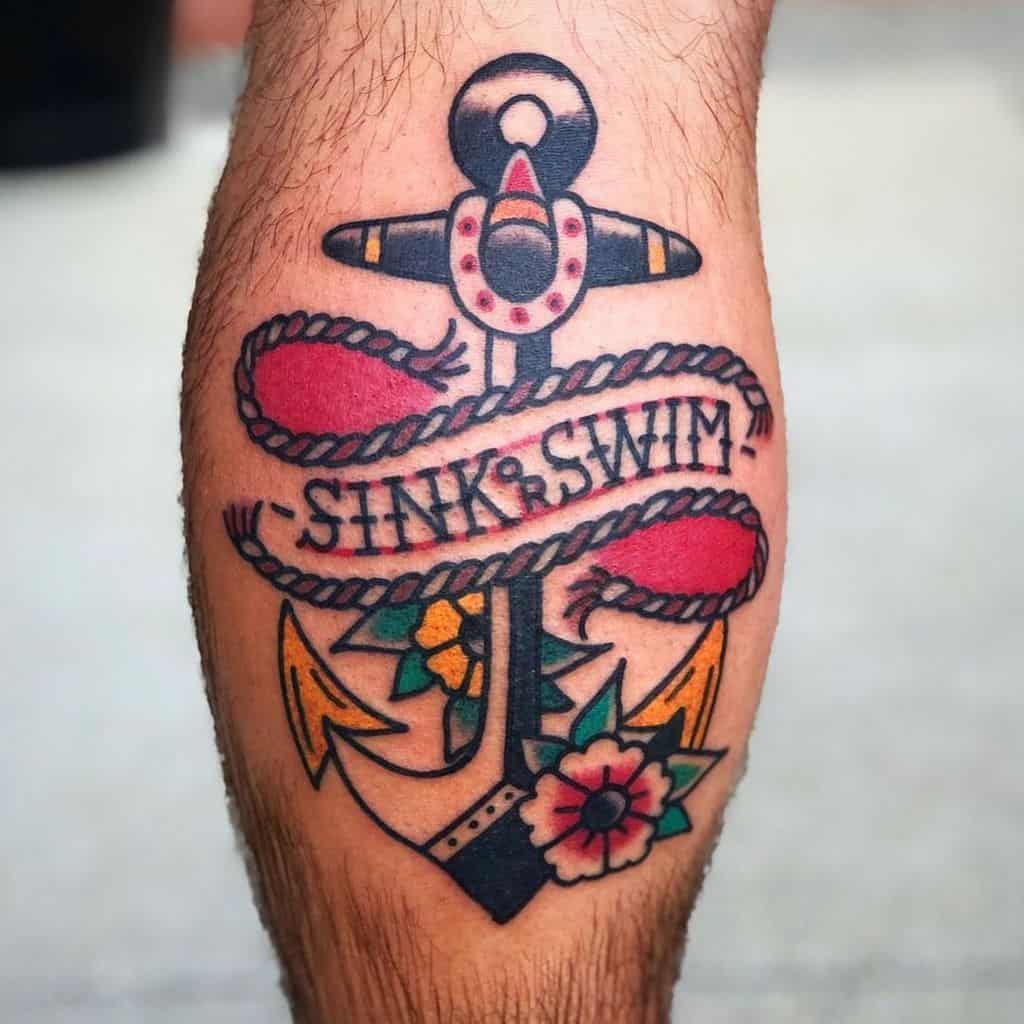 Tattoo of a navy anchor with a rope, flowers, and "Sink or Swim" text on a person's leg