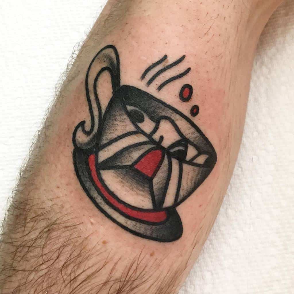 Black and red tattoo of a steaming teacup with a stylized, abstract face design, resting on a saucer