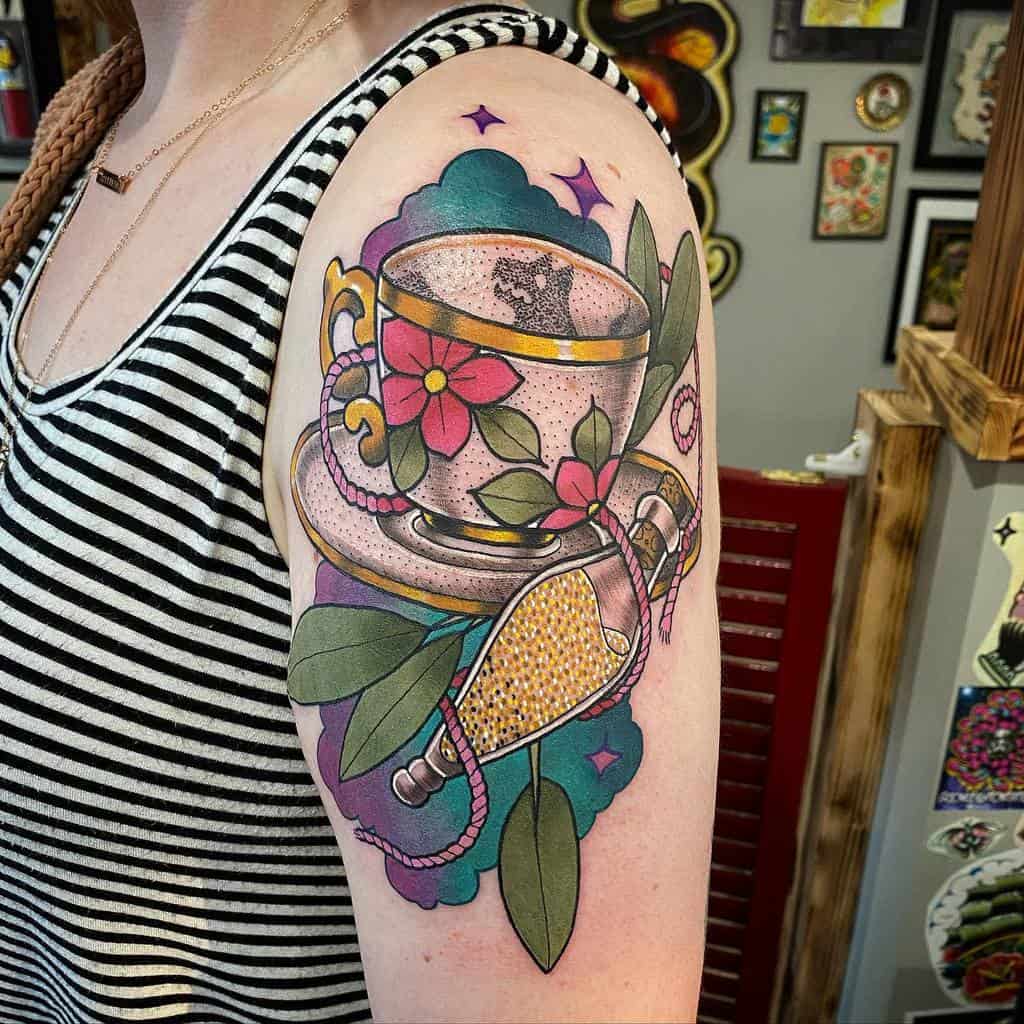 Colorful tattoo of a floral teacup on a saucer, featuring the shadow of a wolf in the cup, with a corked vial of golden liquid tied to the cup with a pink rope, surrounded by leaves and a blue and violet clouds with stars