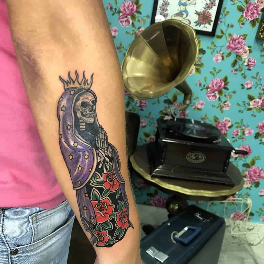 Vibrant Santa Muerte tattoo with purple robe, stars, and red roses, blending life and death themes