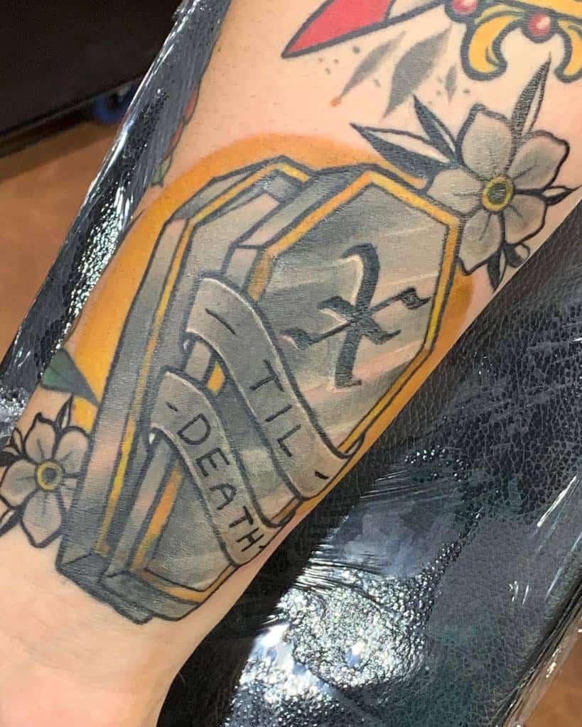 Straight edge tattoo of a coffin with a banner reading "Til Death," surrounded by flowers and has a symbol of "X"
