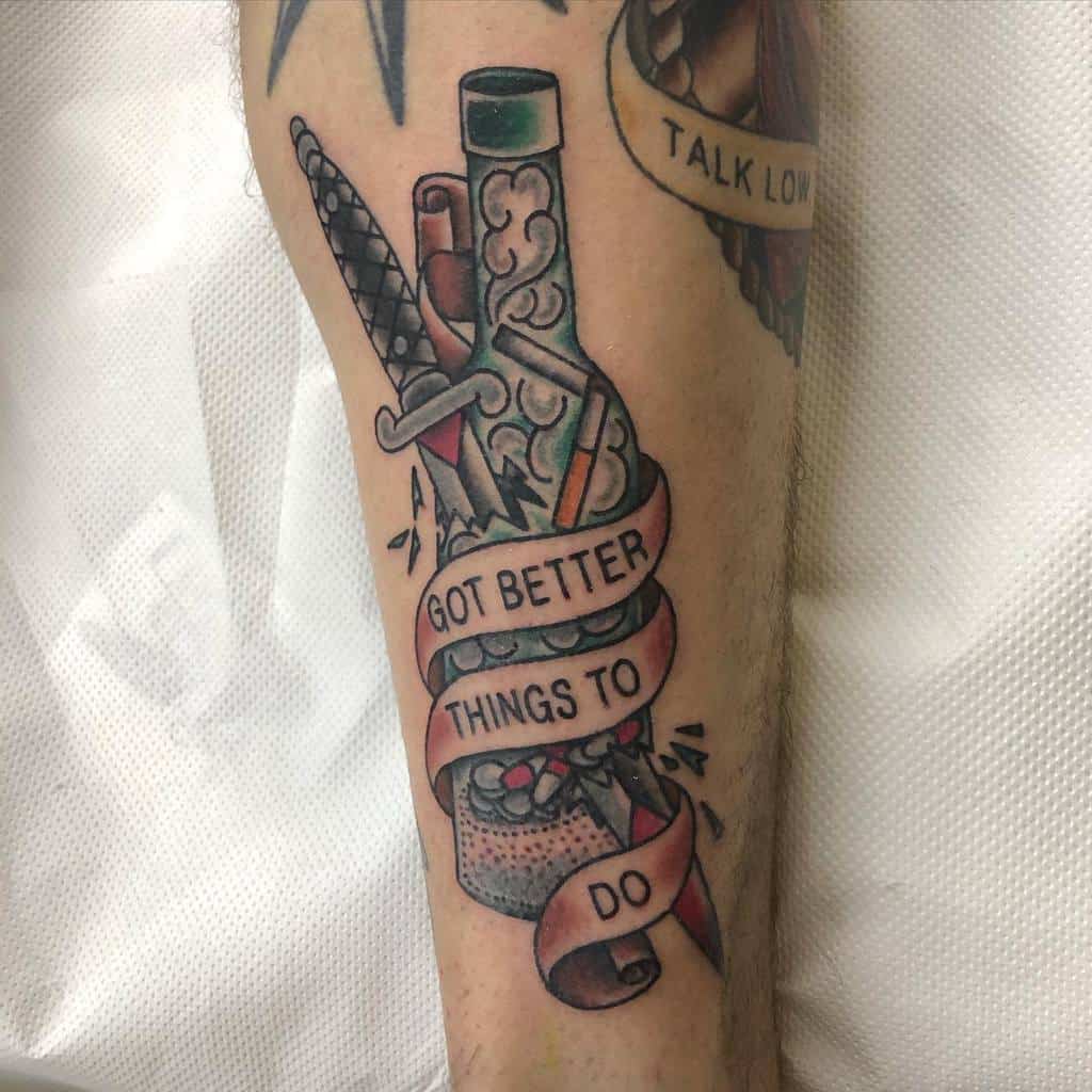 Straight edge tattoo of a bottle with pills, smoke from cigarette, a knife stabbing the bottle with brown note and a banner reading "Got better things to do"