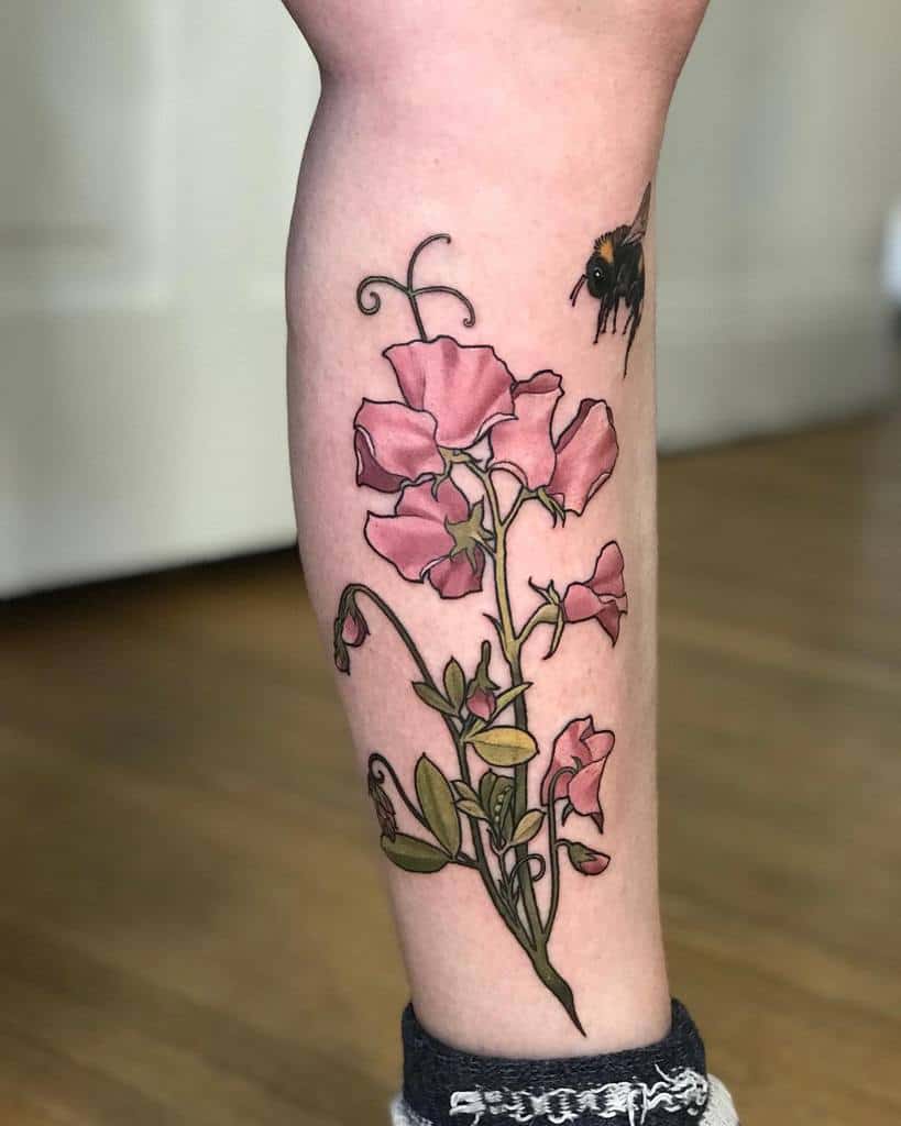 A charming tattoo featuring pink sweet pea flowers and a buzzing bee, symbolizing nature's beauty