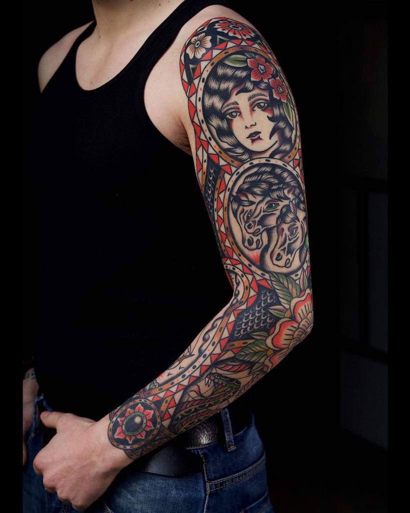 Traditional tattoo sleeve showcasing a vintage female portrait, detailed horses, and bold floral designs in vibrant colors