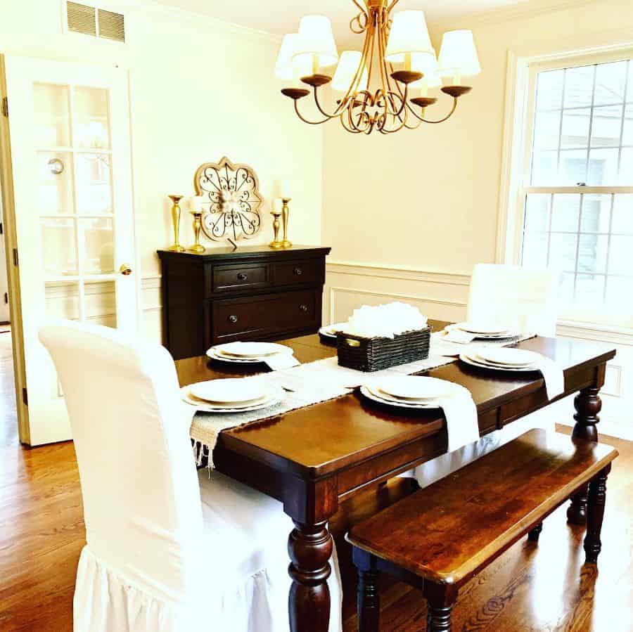 dining room wood table white chairs candlesticks chandelier