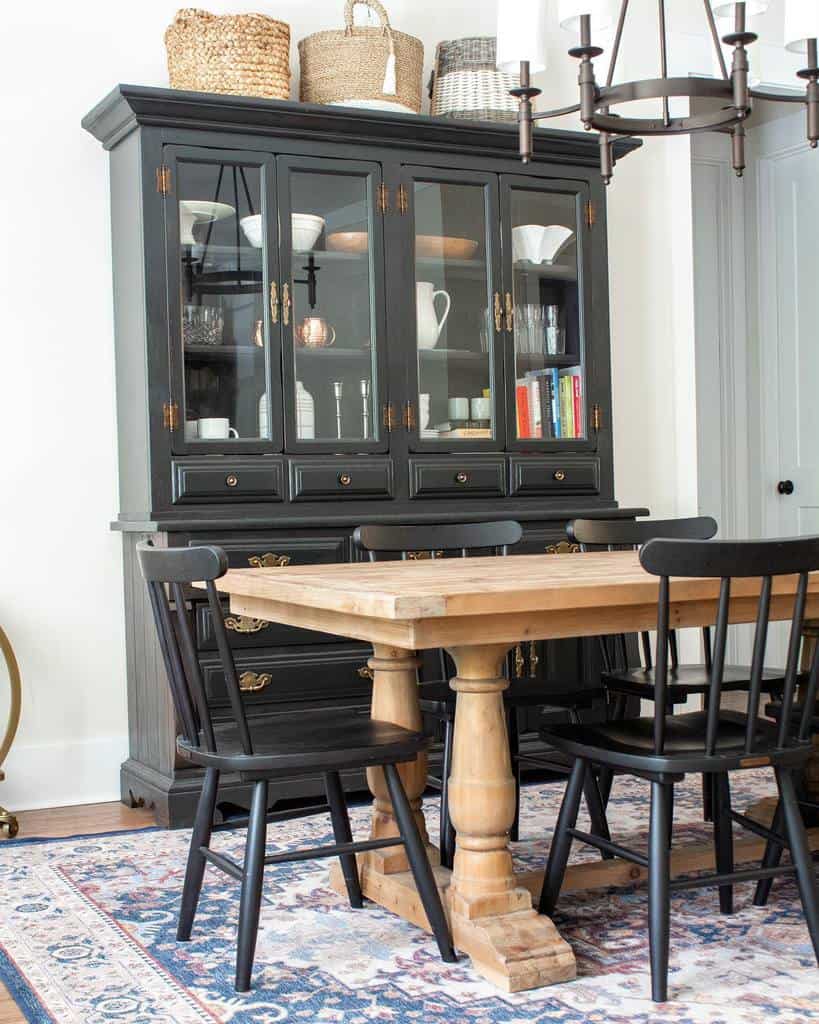 transitional dining room with black cabinet and wood table