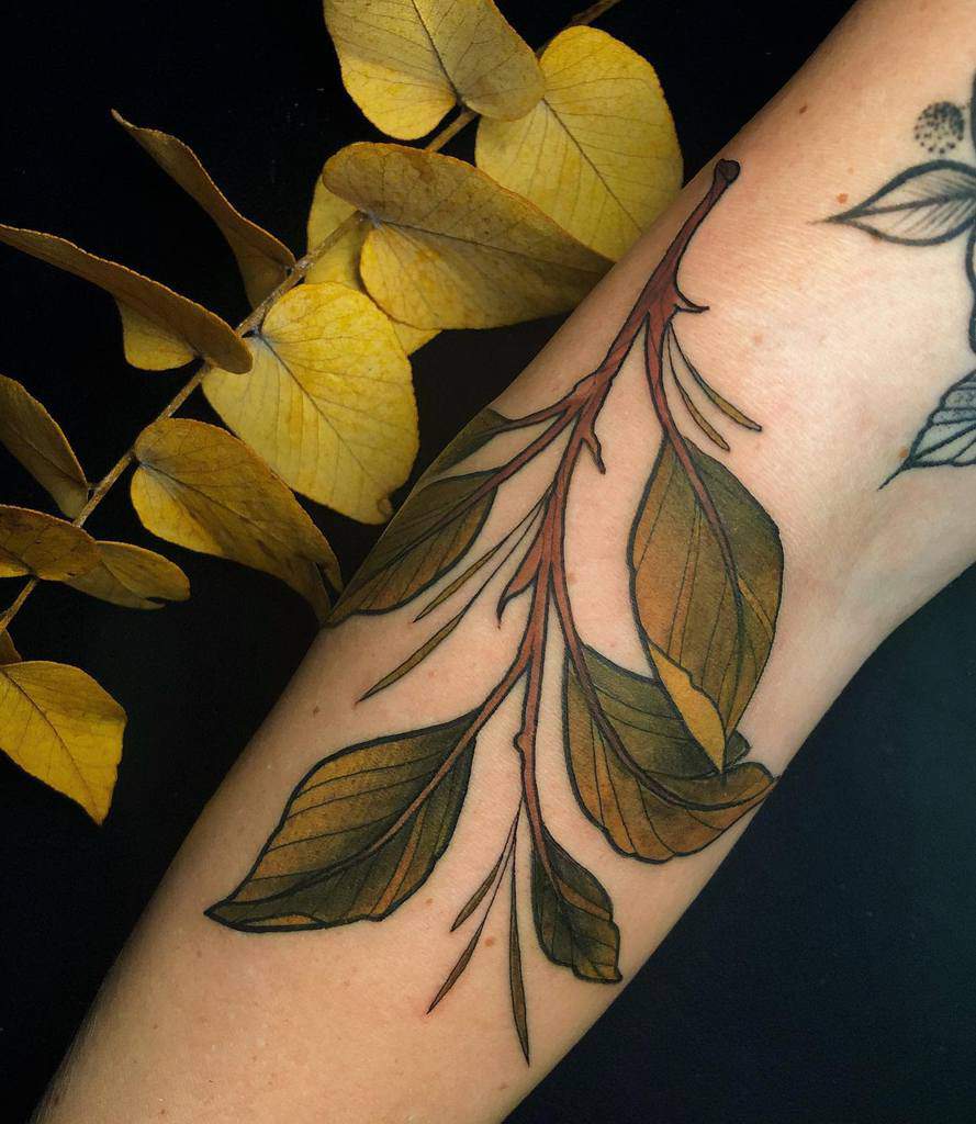 Realistic botanical tattoo of a branch with detailed autumn-toned leaves, blending warm hues and fine linework for a natural and organic look.