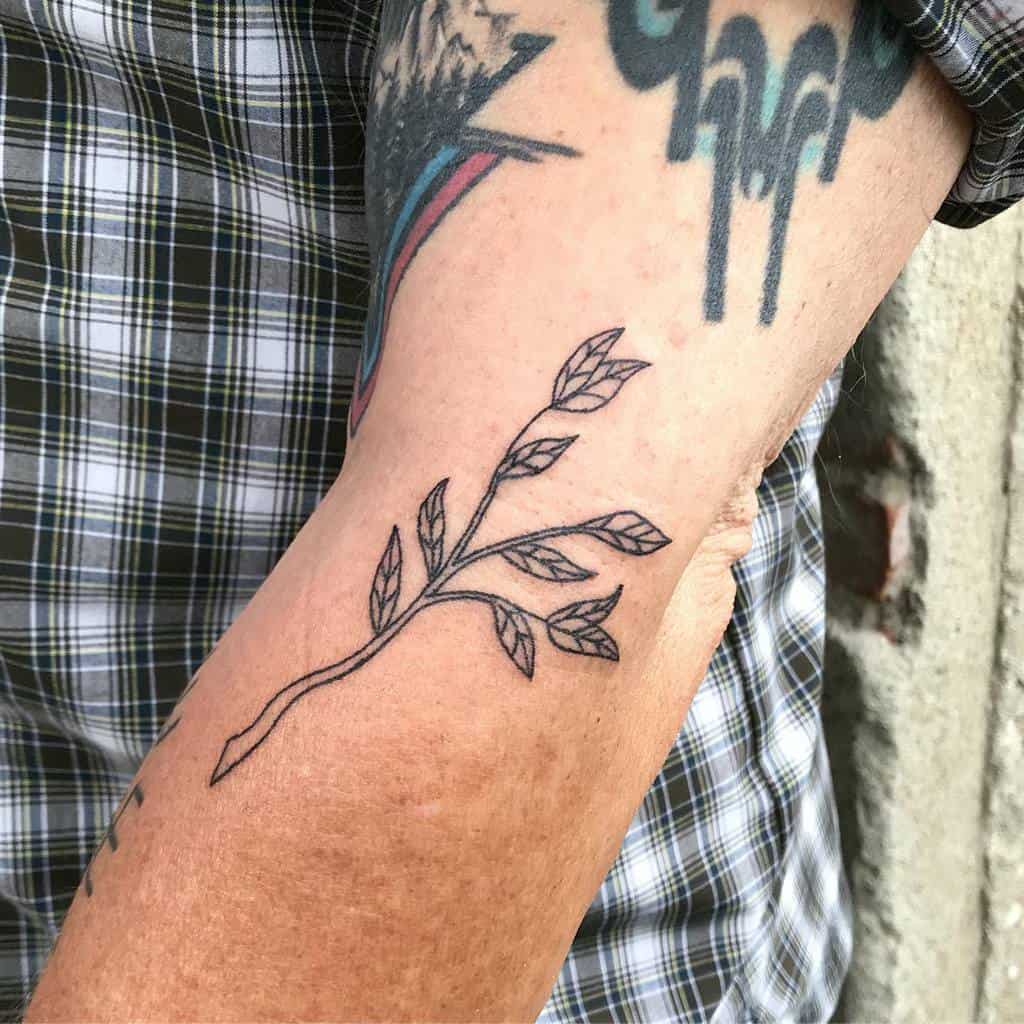 Forearm tattoo of a geometric branch with leaves