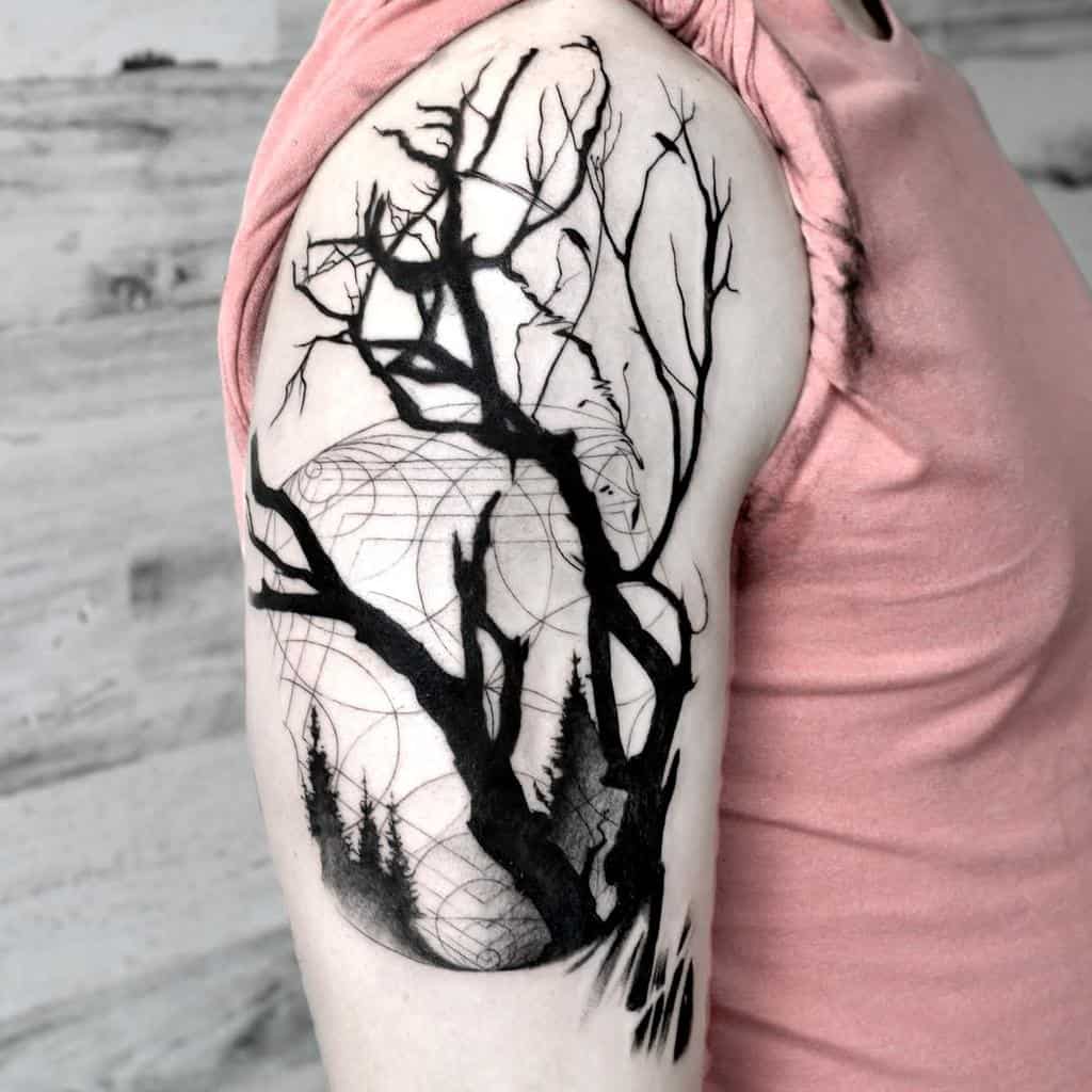 Black and grey upper arm tattoo of a twisted, leafless tree silhouetted against a geometric full moon, with pine trees below, creating a dark and mystical forest scene.