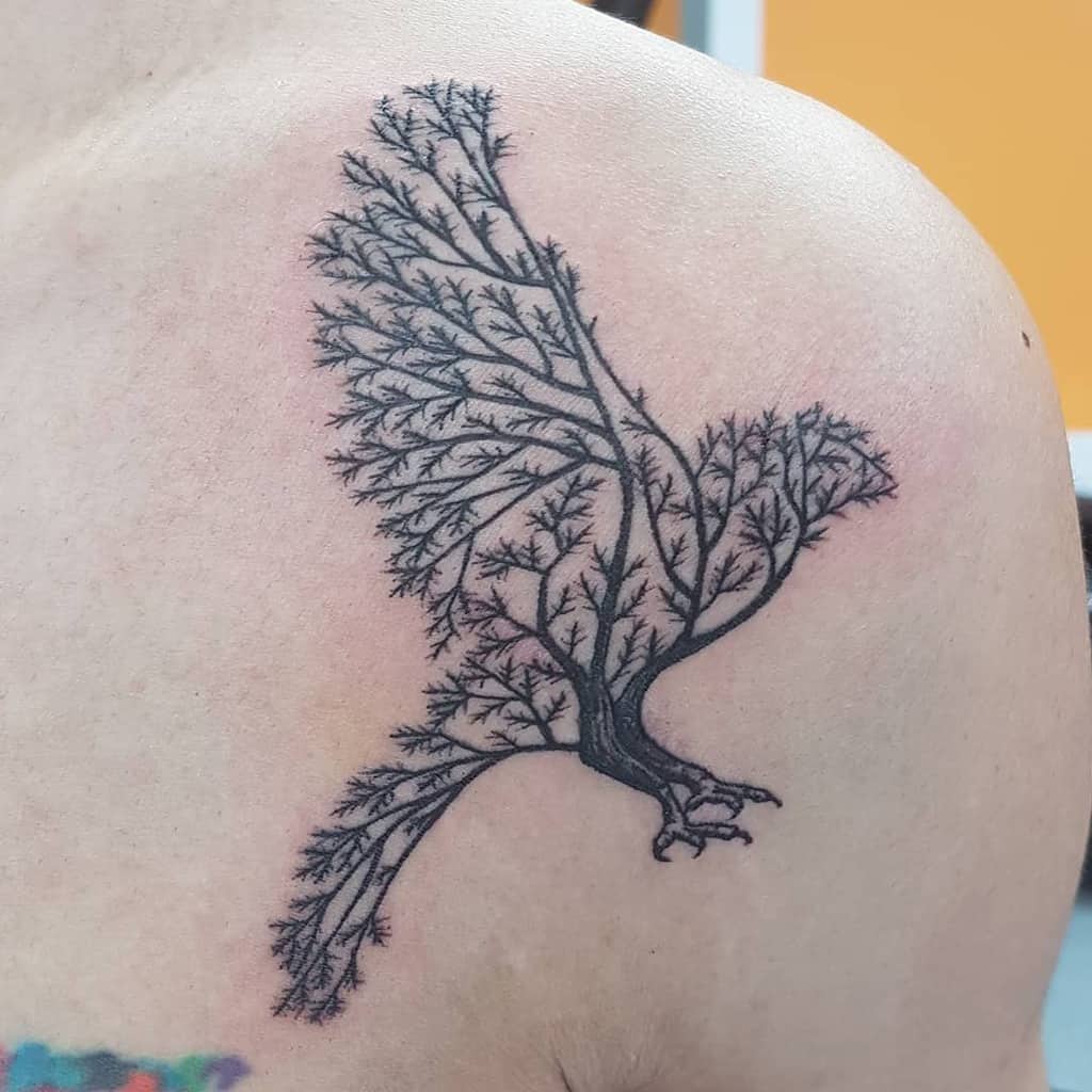 Unique black ink tattoo of an eagle composed of intricate tree branches, symbolizing strength, freedom, and a deep connection to nature.