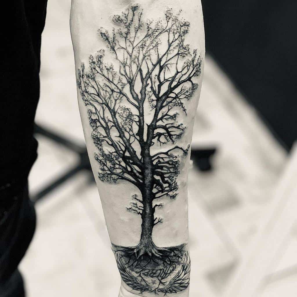 Forearm tattoo of a tree with intricate branches and roots, done in black and white ink