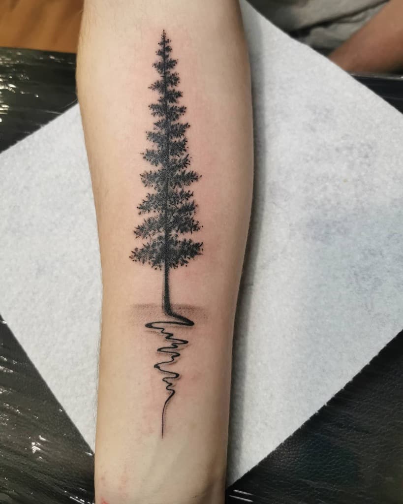 Forearm tattoo of a tree with roots forming a soundwave pattern