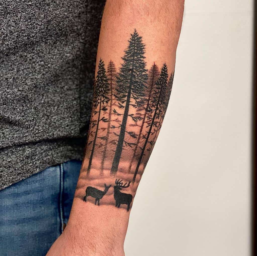 Forearm tattoo featuring a silhouette of a forest with two deer at the bottom