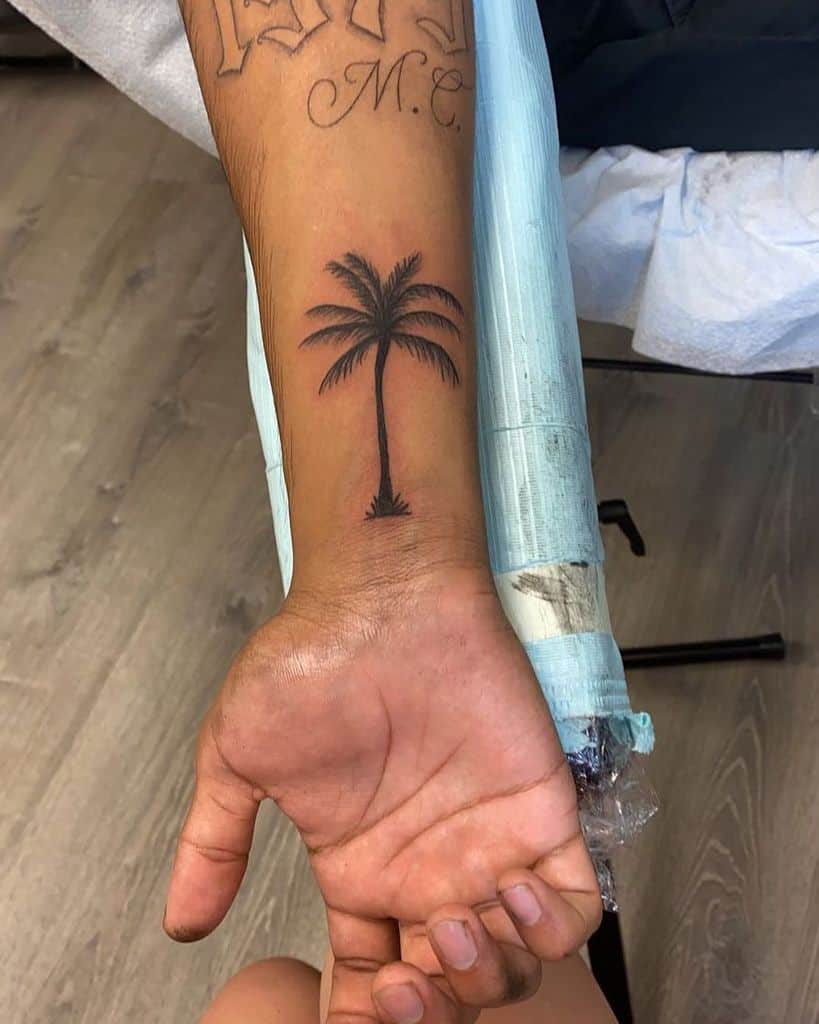 Small wrist tattoo of a palm tree