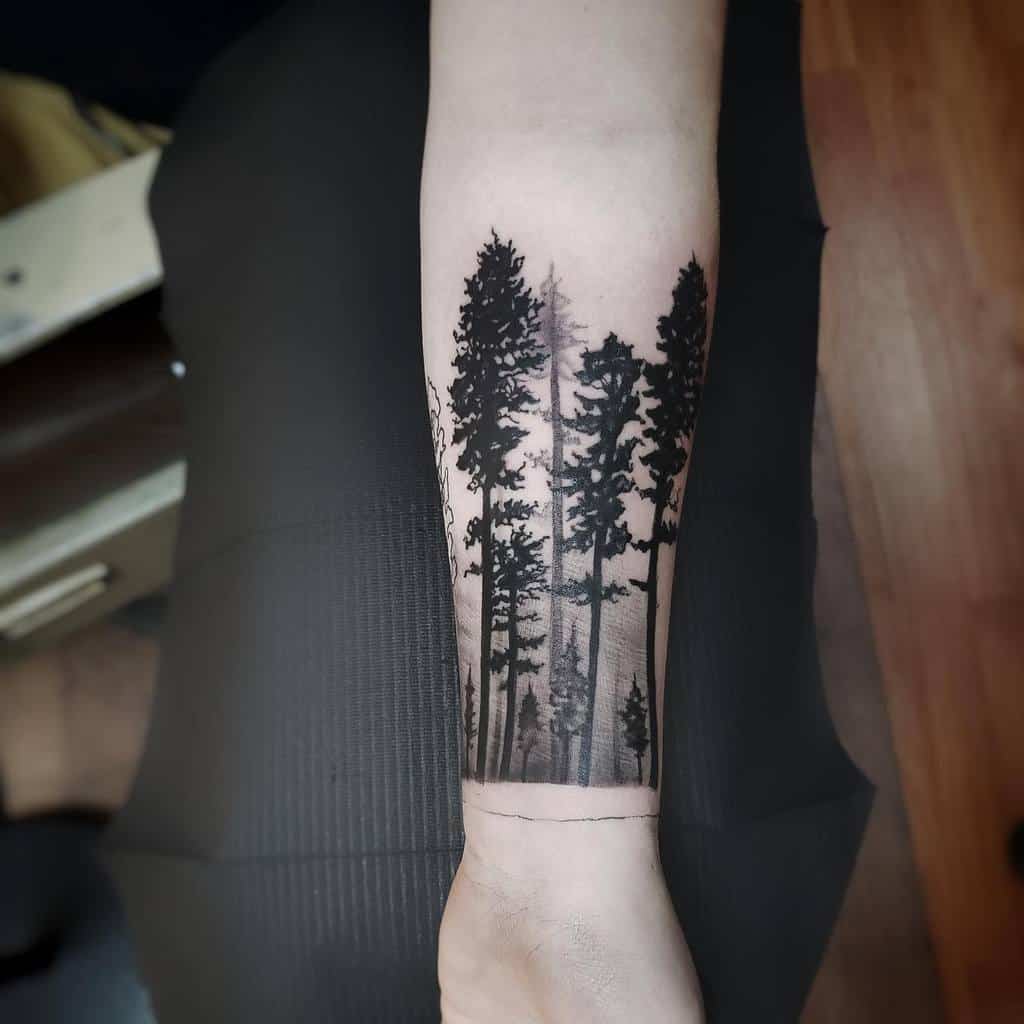 Forearm tattoo of tall pine trees in a minimalist, black and grey style