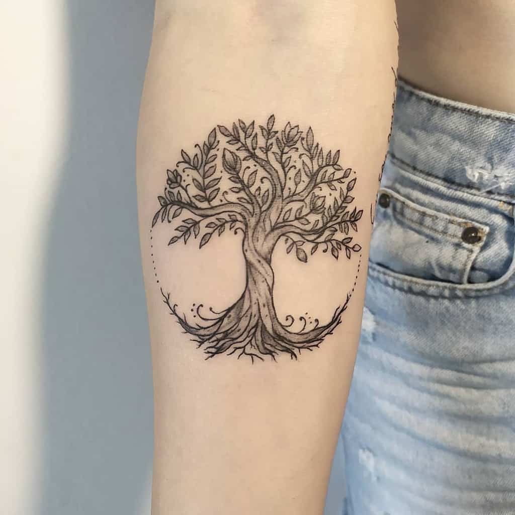 Tattoo of a detailed tree with roots and leaves on an inner forearm