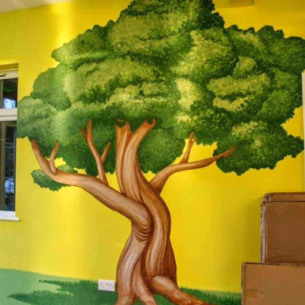 tree mural painted on yellow outside wall