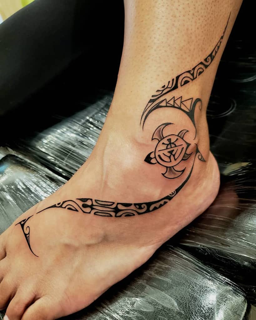 Tribal turtle tattoo design on a person's foot and ankle, featuring bold, curved lines and patterns