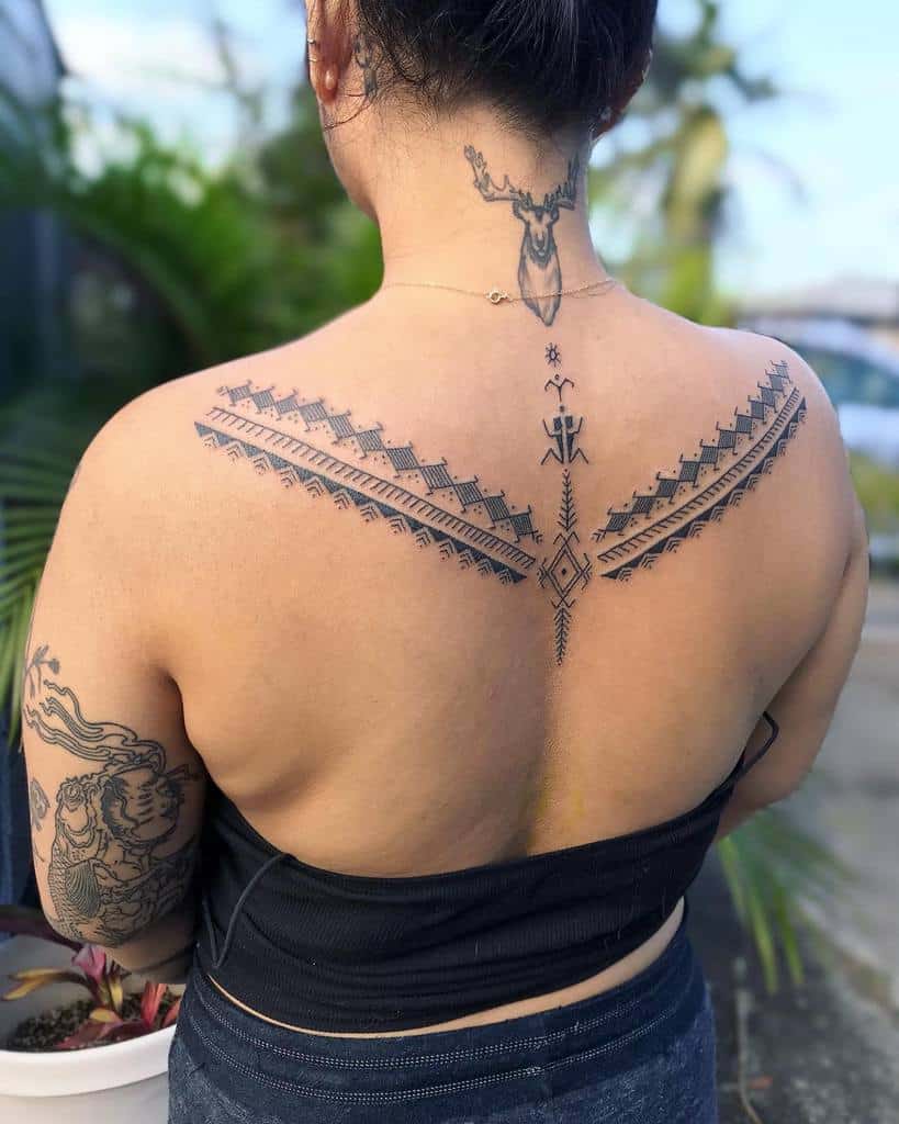 Woman with intricate, tribal style back and neck tattoos