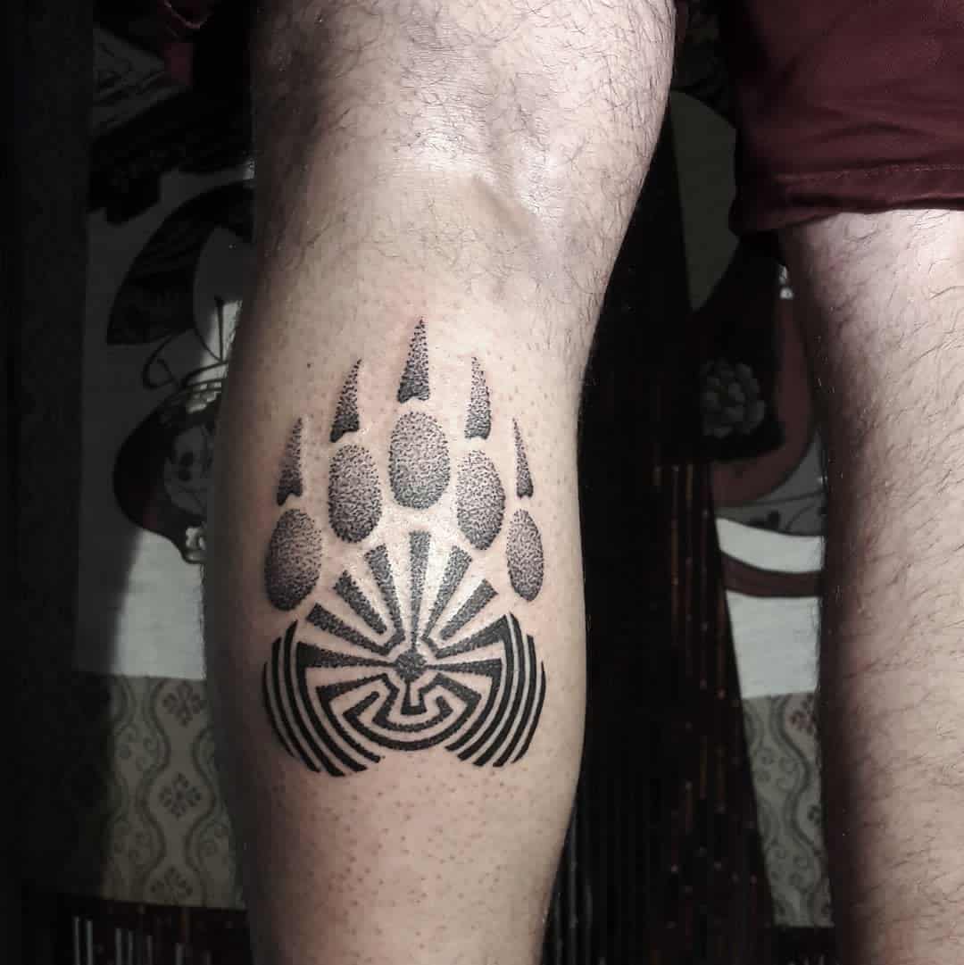 Leg tattoo featuring a stylized bear paw print with intricate geometric design